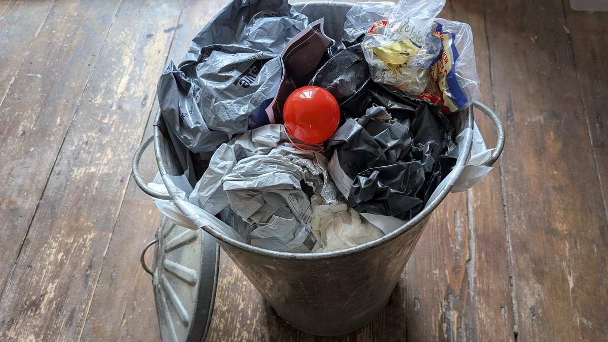 A red clown nose that has been thrown into a bin