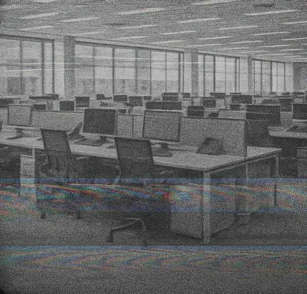 a flickering TV screen displays an empty open plan office with rows and rows of desks and computer stations